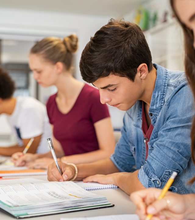 high school students doing exam in classroom